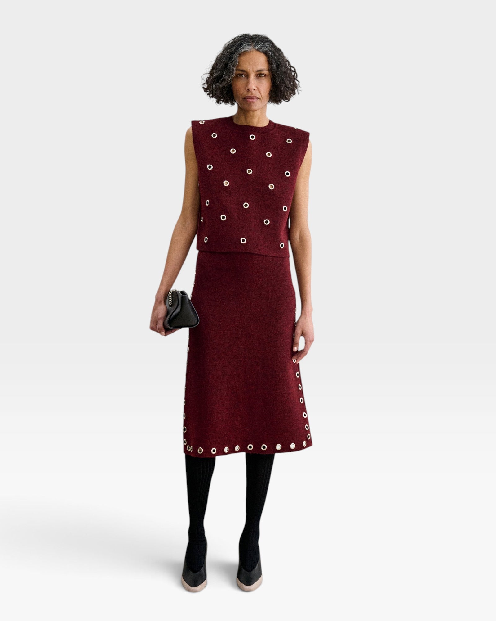 JONES + CO garnet baby alpaca knit vest with metallic eyelet details worn with a matching midi skirt