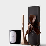 JONES + CO gold USB arc lighter standing next to a black candle and a gift box with a brown ribbon