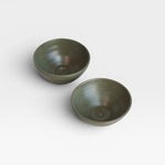 Two JONES + CO handcrafted green ceramic little bowls for snacks, trinkets, or home decor on a white background.
