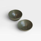 Two JONES + CO handcrafted green ceramic little bowls for snacks, trinkets, or home decor on a white background.