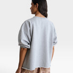 JONES + CO grey crewneck sweatshirt with drop shoulders and raw edge hem worn by a model from the back