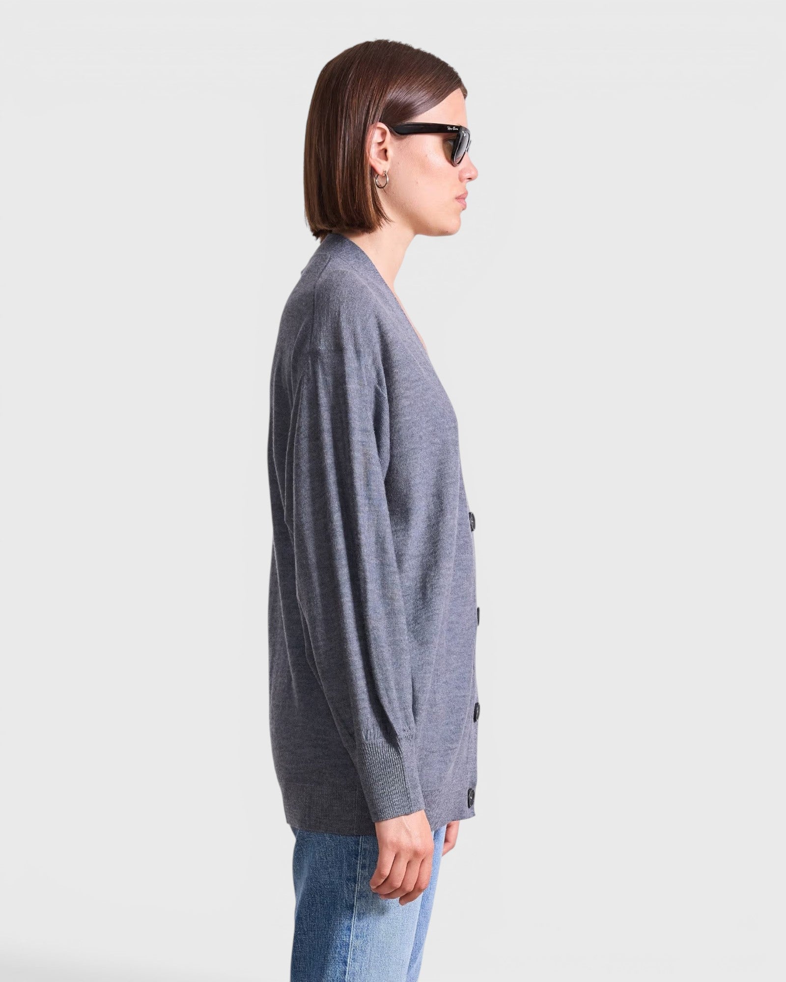 JONES + CO grey lightweight tissue cardigan with side button cinch detail worn by a model in profile view