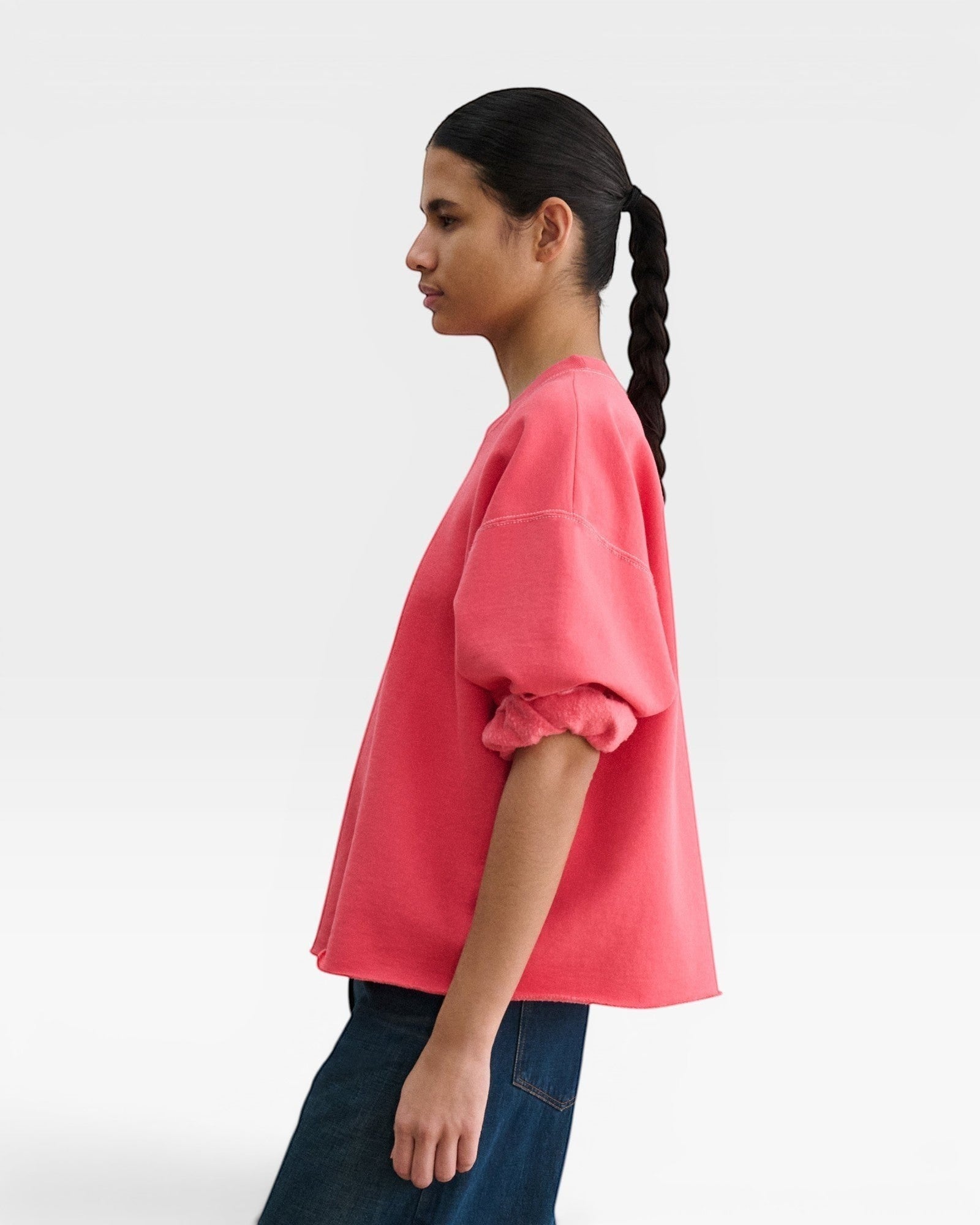 JONES + CO Fond crewneck sweatshirt in guava pink with drop shoulders, cropped sleeves, and raw edge hemline.