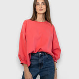 JONES + CO Fond crewneck sweatshirt in guava pink with drop shoulders, cropped sleeves, and raw edge hemline.