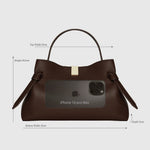 JONES + CO Gyoza pouch in fennel brown suede with a top handle, gold hardware, and size reference to an iPhone 16.