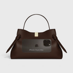 JONES + CO Gyoza pouch in fennel brown suede with a top handle, gold hardware, and size reference to an iPhone 16.