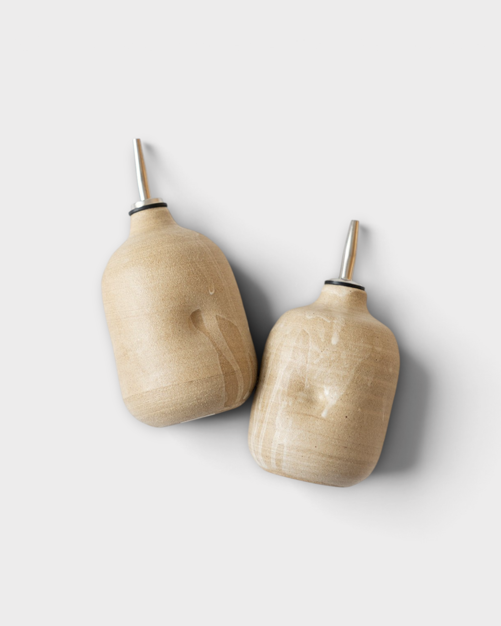 JONES + CO handmade ceramic olive oil cruets with a natural beige glaze and stainless steel pour spouts