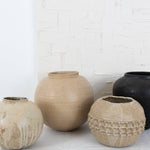 JONES + CO handthrown ceramic vases in neutral earth tones with textured and smooth finishes on a white surface.