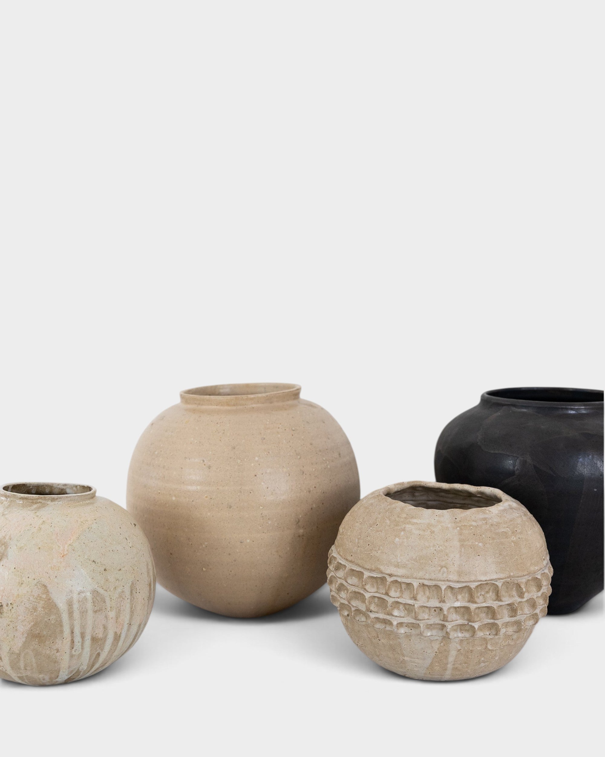 JONES + CO collection of four unique handthrown ceramic vases in neutral and black tones with textured finishes