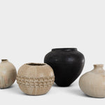 JONES + CO collection of four unique handthrown ceramic vases in neutral beige and matte black finishes.