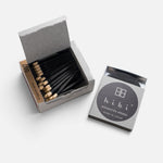 JONES + CO Hibi Japanese Wisteria incense matches in a grey box with black matchsticks and a striking surface.