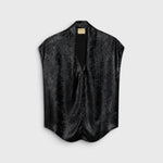 JONES + CO Hildra sleeveless black blouse in fluid laminated fabric with a V-neck and shawl collar.