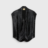 JONES + CO Hildra sleeveless black blouse in fluid laminated fabric with a V-neck and shawl collar.