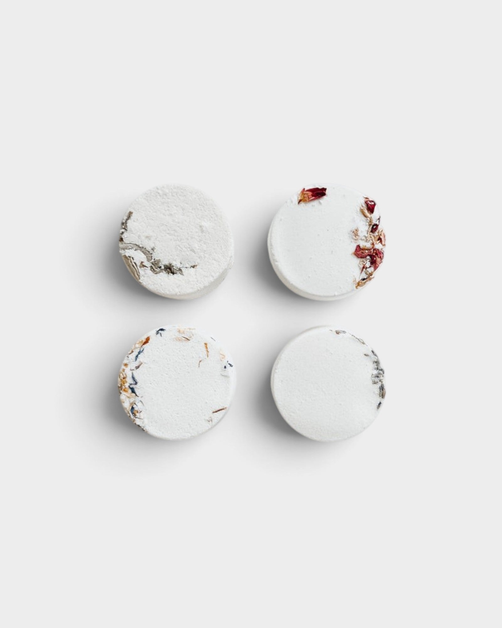 JONES + CO Hinoki shower steamers in a set of four round white tablets with dried botanical accents