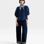 Model wearing a JONES + CO Rachel Comey indigo cropped sweatshirt with dropped shoulders and raw-edge hem.