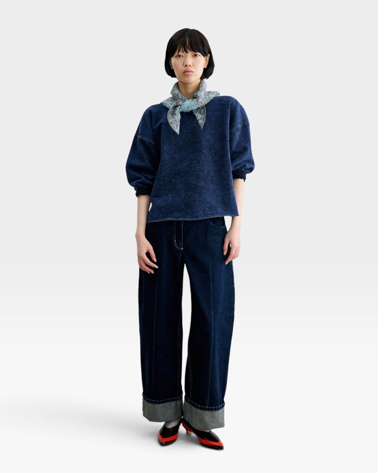 Model wearing a JONES + CO Rachel Comey indigo cropped sweatshirt with dropped shoulders and raw-edge hem.