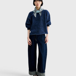 Model wearing a JONES + CO Rachel Comey indigo cropped sweatshirt with dropped shoulders and raw-edge hem.