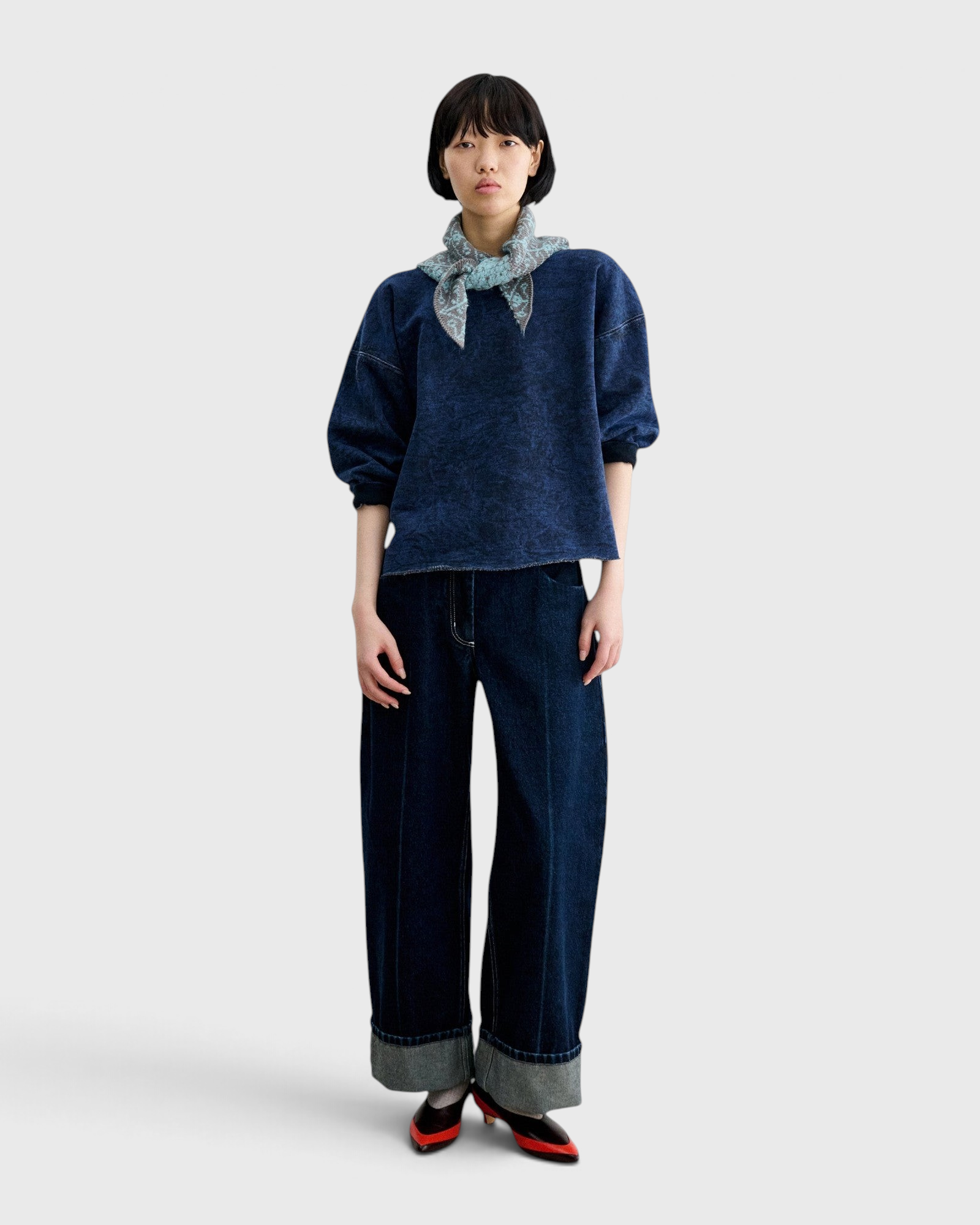 Model wearing a JONES + CO Rachel Comey indigo cropped sweatshirt with dropped shoulders and raw-edge hem.