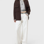 JONES + CO Jayla ivory white wide-leg rigid denim jeans worn by a model with a brown jacket and grey polo shirt