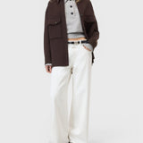 JONES + CO Jayla ivory white wide-leg rigid denim jeans worn by a model with a brown jacket and grey polo shirt