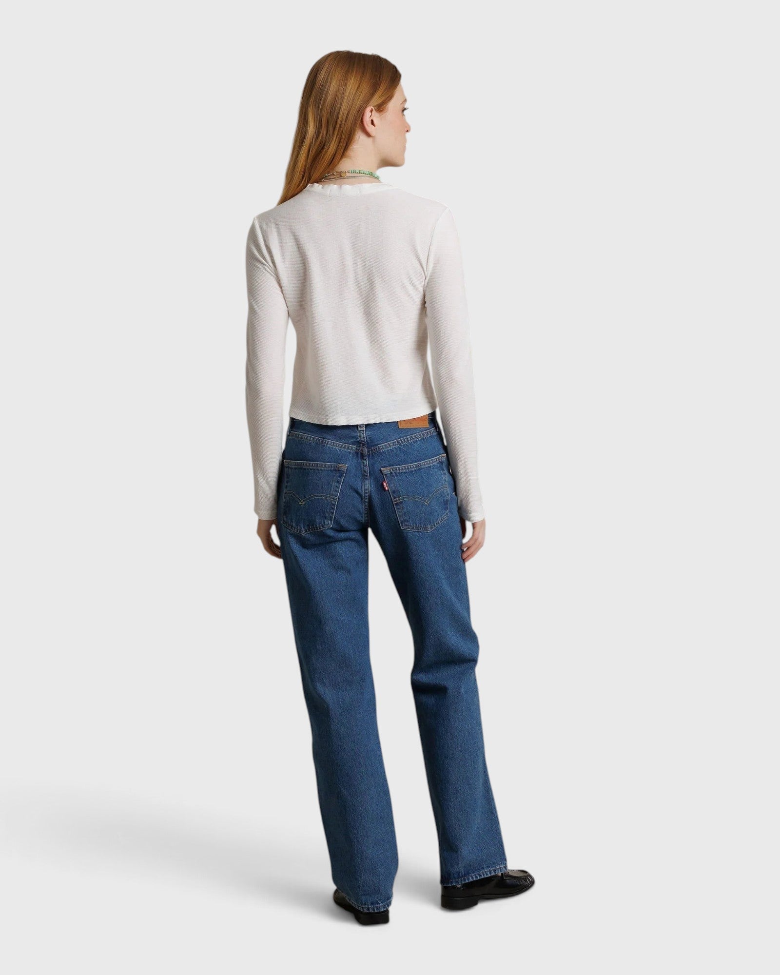 JONES + CO Jamie long-sleeve recycled cotton tee in whitecap grey, shown from the back on a model with blue jeans.