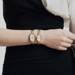 JONES + CO Jane Small Tethered watch with champagne mother of pearl dial and gold woven mesh bracelet on a wrist