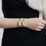 JONES + CO Jane Small Tethered watch with champagne mother of pearl dial and gold woven mesh bracelet on a wrist