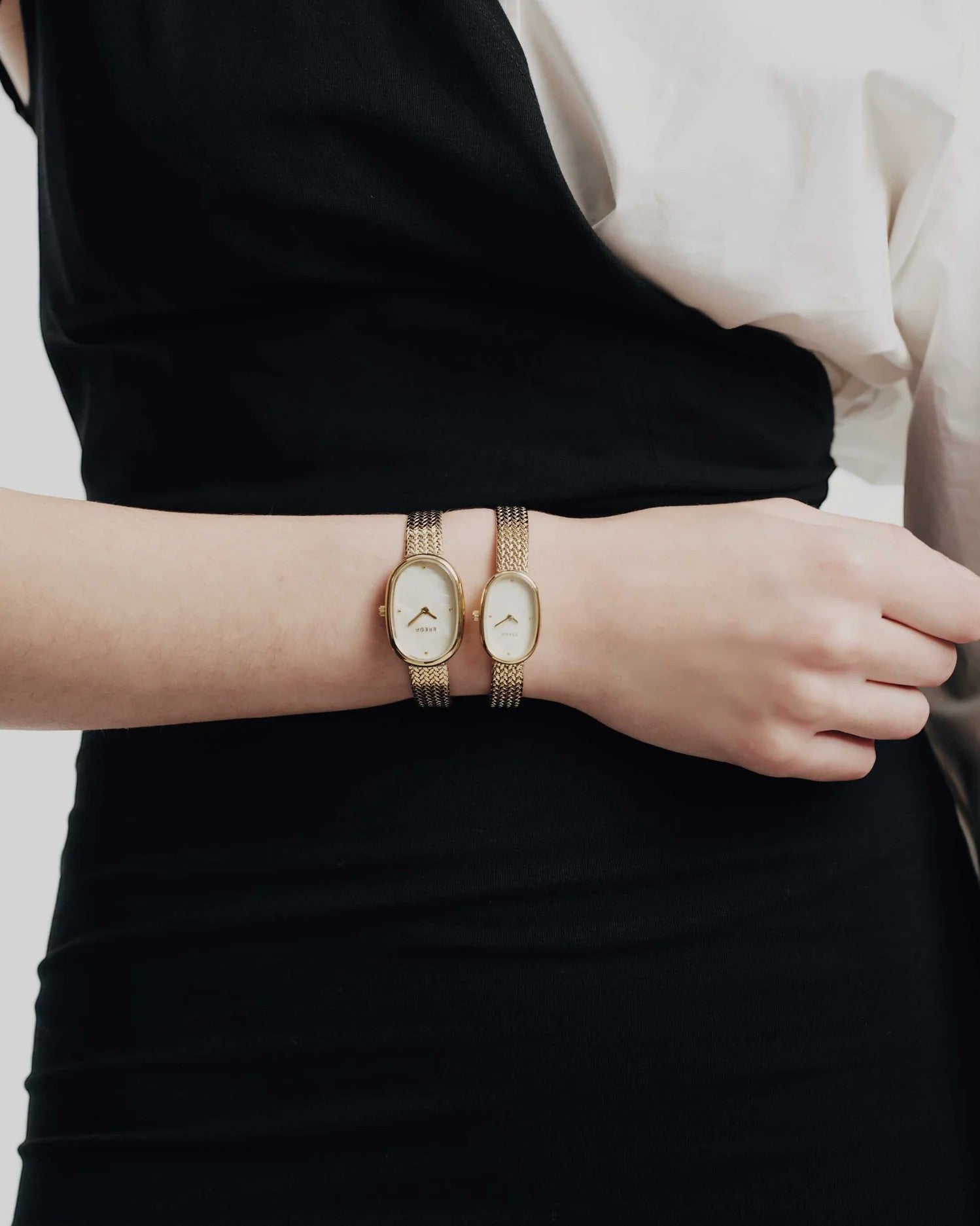 JONES + CO Jane Small Tethered watch with champagne mother of pearl dial and gold woven mesh bracelet on a wrist
