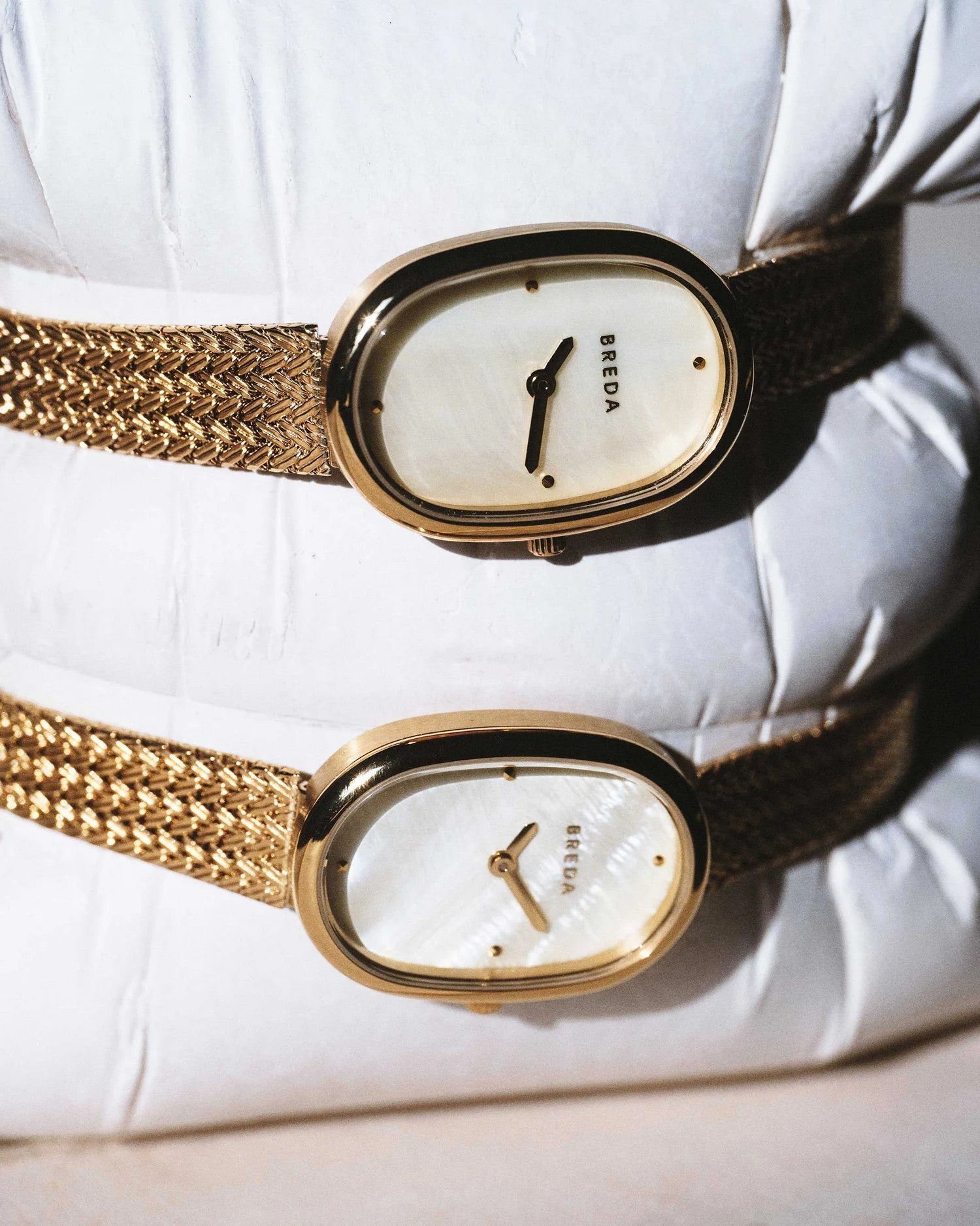 JONES + CO Jane Tethered watch featuring a 23mm oval gold case, champagne mother-of-pearl dial, and woven mesh bracelet.