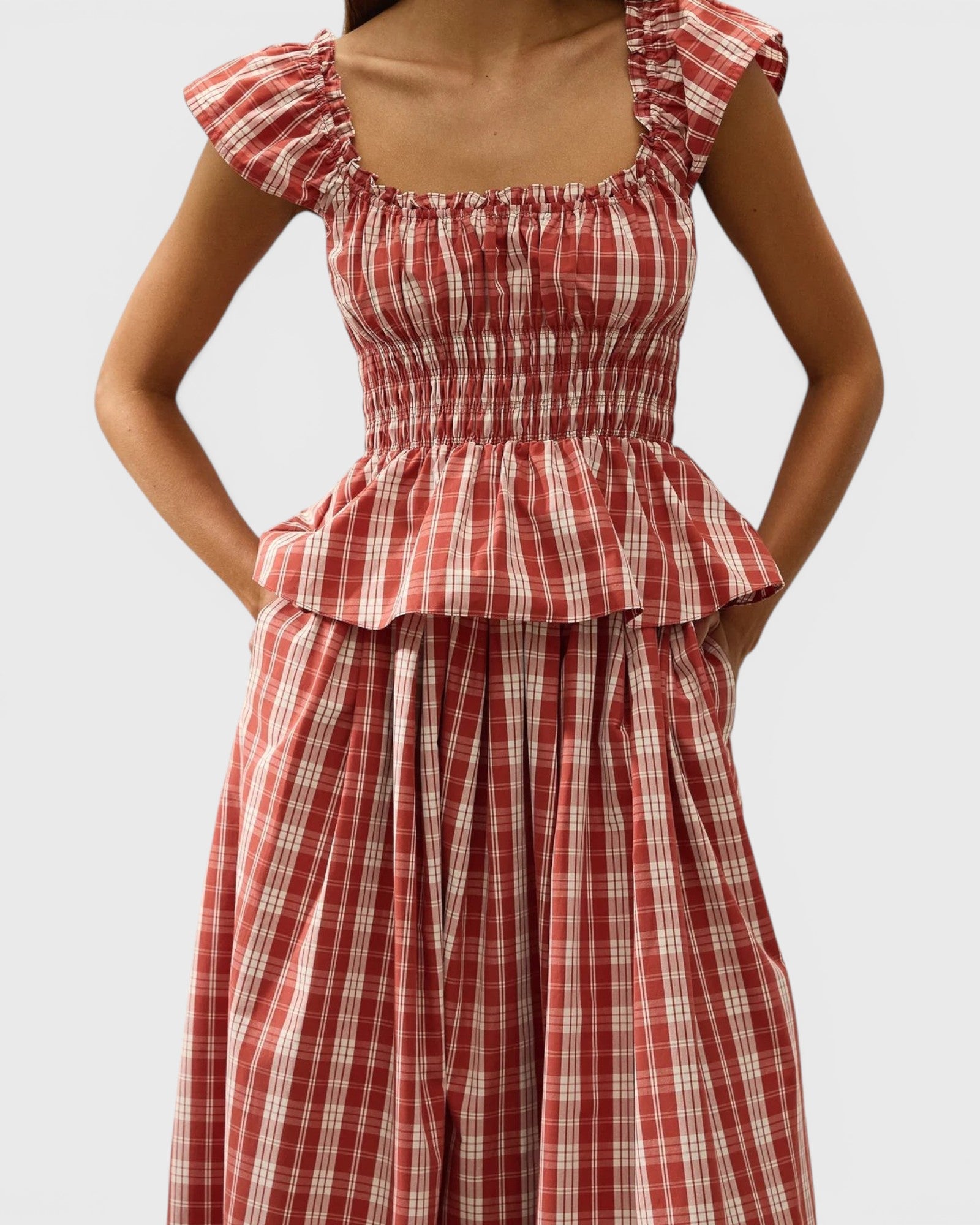 JONES + CO Janne top in terra rosso check with square neckline, cap sleeves, and shirred waist on a model