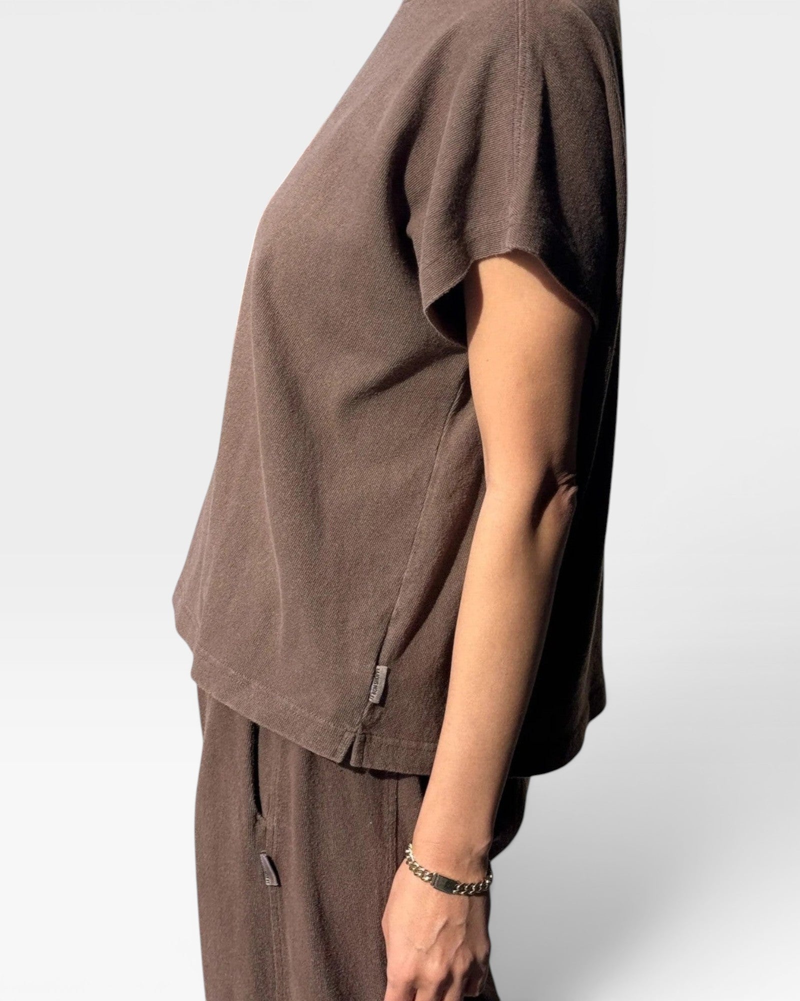 JONES + CO Jeanne muscle tee in chocolate brown with dolman sleeves and a cropped fit, side view on a model.