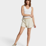 JONES + CO Layla French Terry sweat shorts in sugar beige with an elastic waistband and raw edge hem on a model.