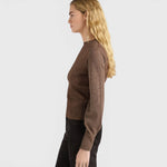 JONES + CO Loa ribbed lurex turtleneck top in caramello brown with long amphora sleeves on a model, side view.