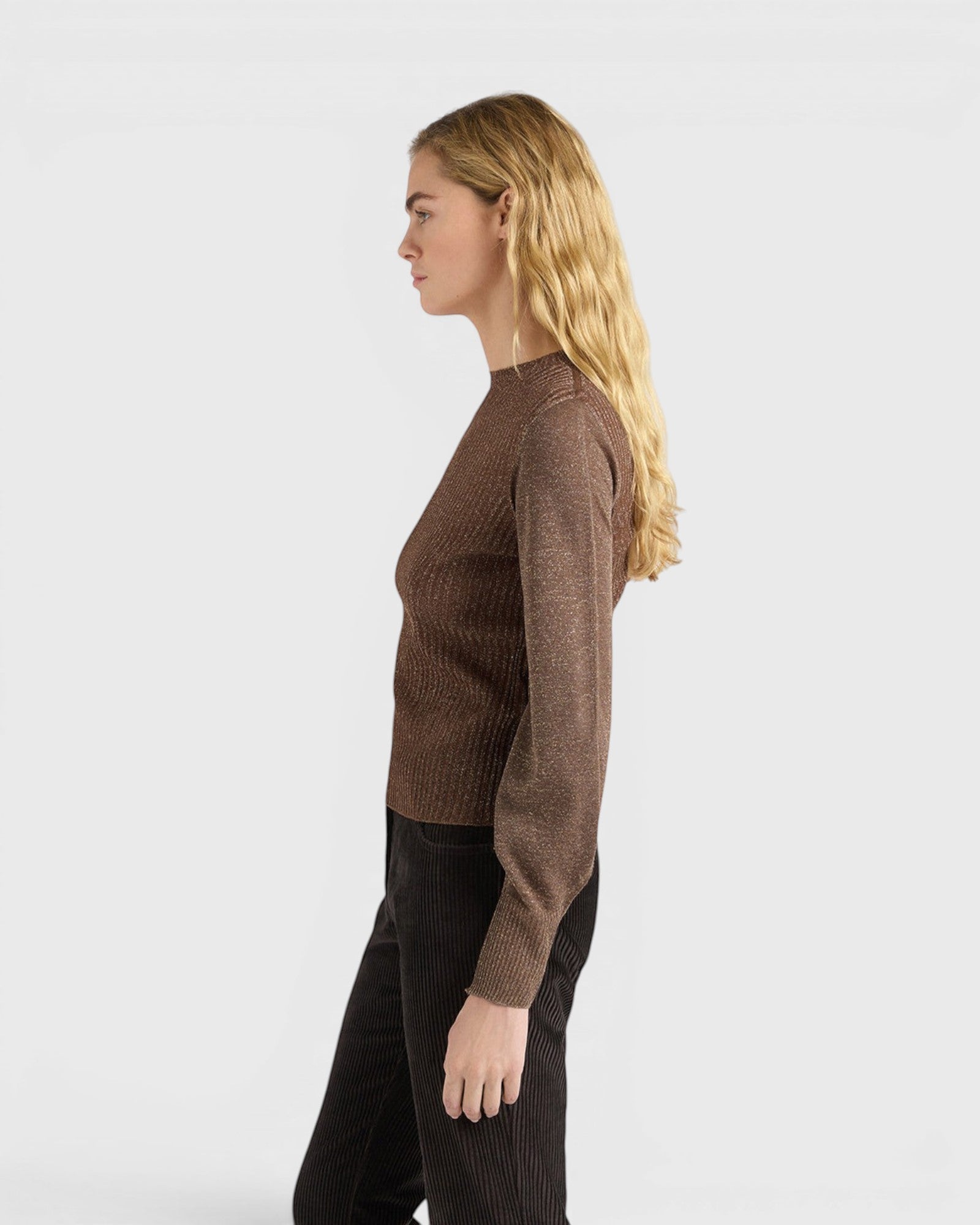 JONES + CO Loa ribbed lurex turtleneck top in caramello brown with long amphora sleeves on a model, side view.