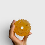 JONES + CO lülala basil and mandarin soap bar with calendula petals held in a hand against a white background.