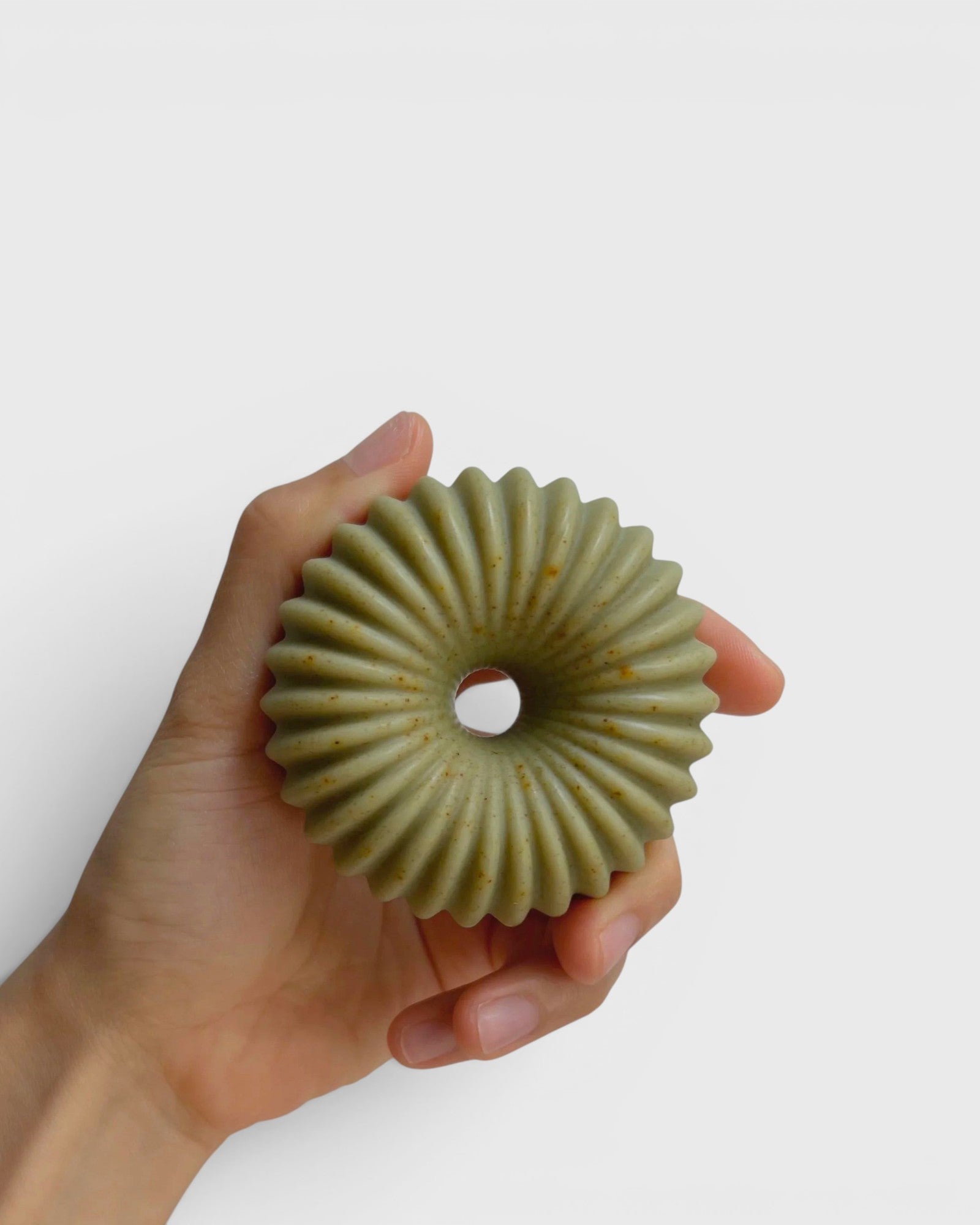 JONES + CO lülala May Chang and Coriander soap bar with a unique ribbed geometric shape held in a hand.