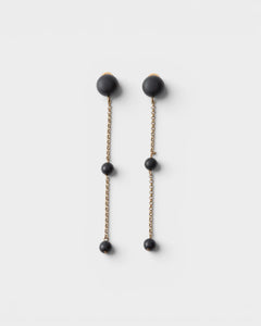 JONES + CO Morse long drop earrings in matte black with brass chain links and resin beads.
