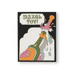 JONES + CO Mazel Tov greeting card featuring a retro illustration of a champagne bottle popping on heavy card stock.