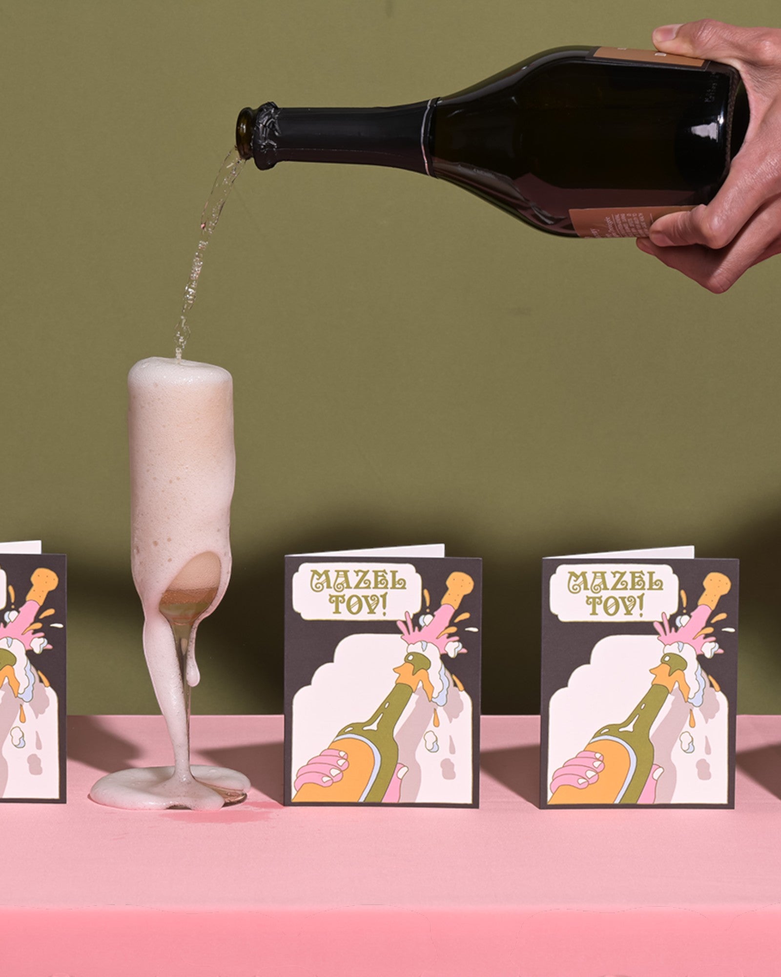 JONES + CO Mazel Tov greeting card featuring a champagne bottle illustration on heavyweight recycled paper