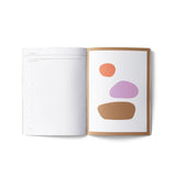 JONES + CO Me-est Me Journal open to a page with guided prompts and organic abstract art by Hanna Snyder