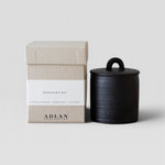 JONES + CO Midnight Oil petite candle in a black stoneware vessel with a matching lid and textured gift box.