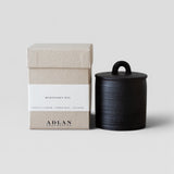 JONES + CO Midnight Oil petite candle in a black stoneware vessel with a matching lid and textured gift box.