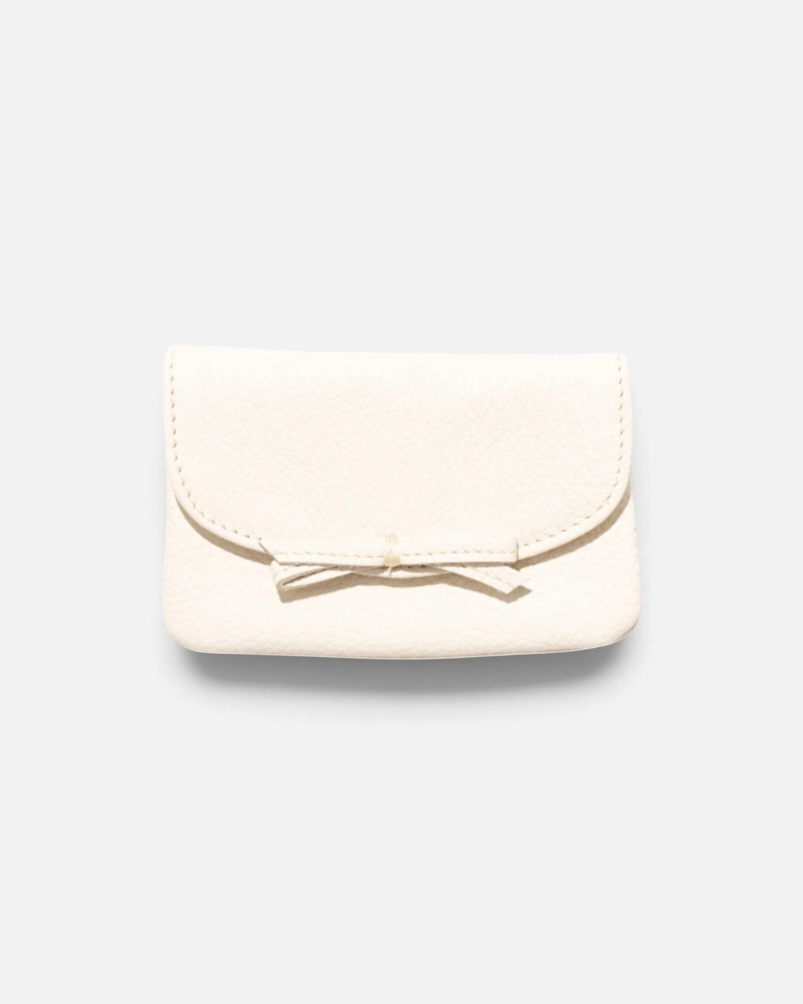 JONES + CO milk pebble grain leather petite case featuring a delicate knotted bow on the front flap