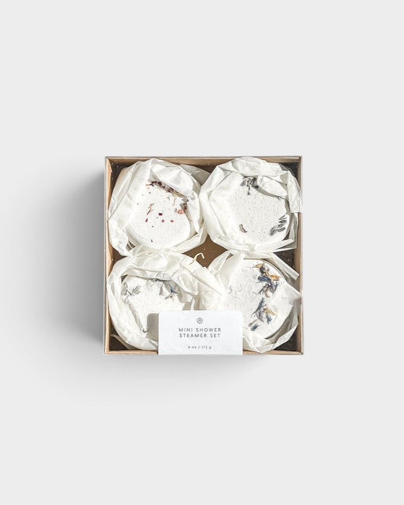 JONES + CO mini shower steamer set featuring four assorted aromatherapy tablets with dried floral botanicals in a box