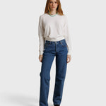 Model wearing a JONES + CO natural textured jersey crew neck sweater with long sleeves and blue denim jeans