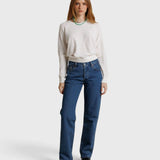 Model wearing a JONES + CO natural textured jersey crew neck sweater with long sleeves and blue denim jeans