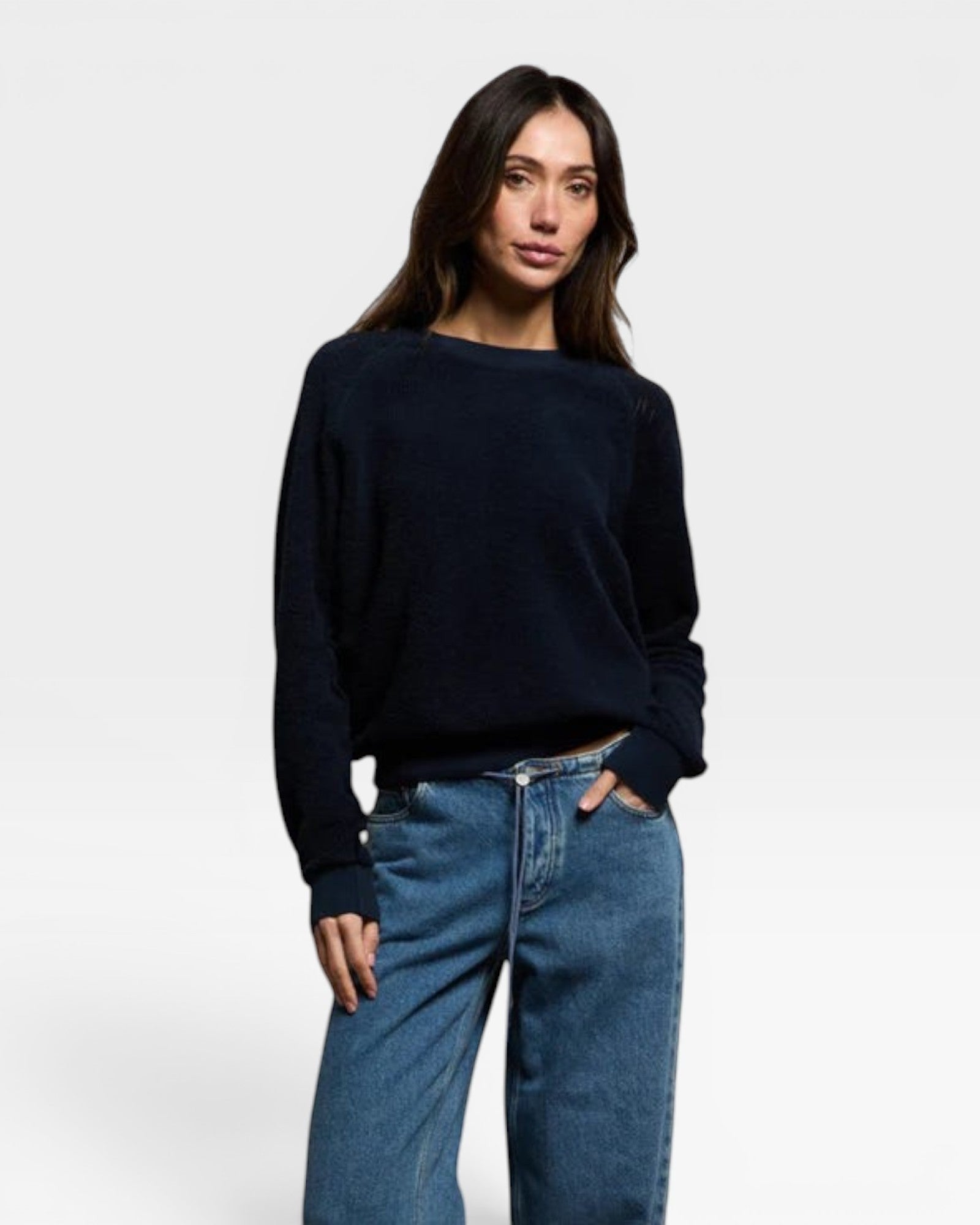 Model wearing a JONES + CO navy blue Ziggy sweatshirt with long sleeves and a crew neckline paired with blue jeans