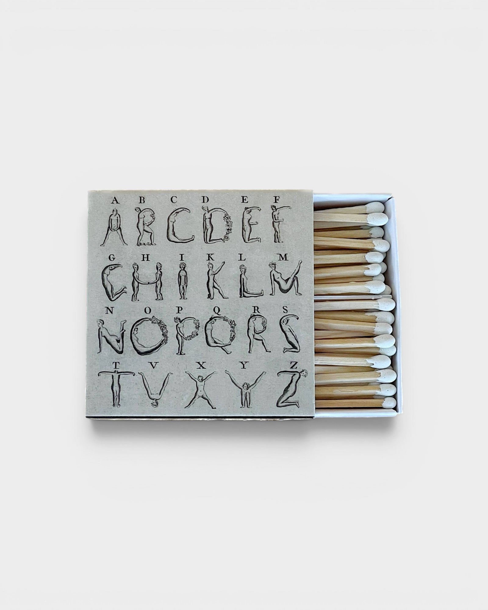 JONES + CO Nue matchbox featuring a grey cover with an artistic alphabet illustration and white-tipped wooden matches.
