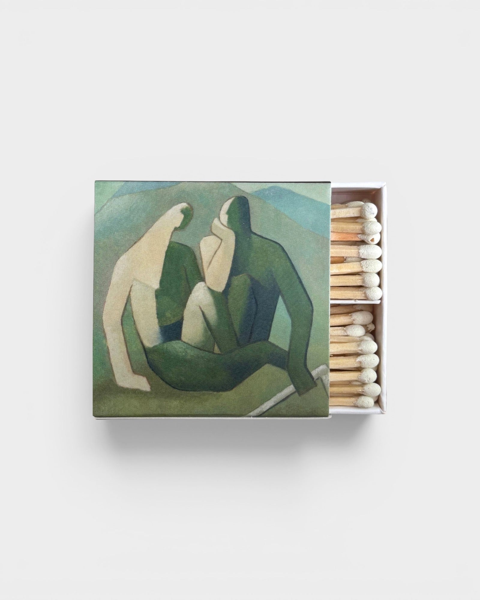 JONES + CO Nue matchbox featuring artistic green and cream abstract figures with wooden matches inside