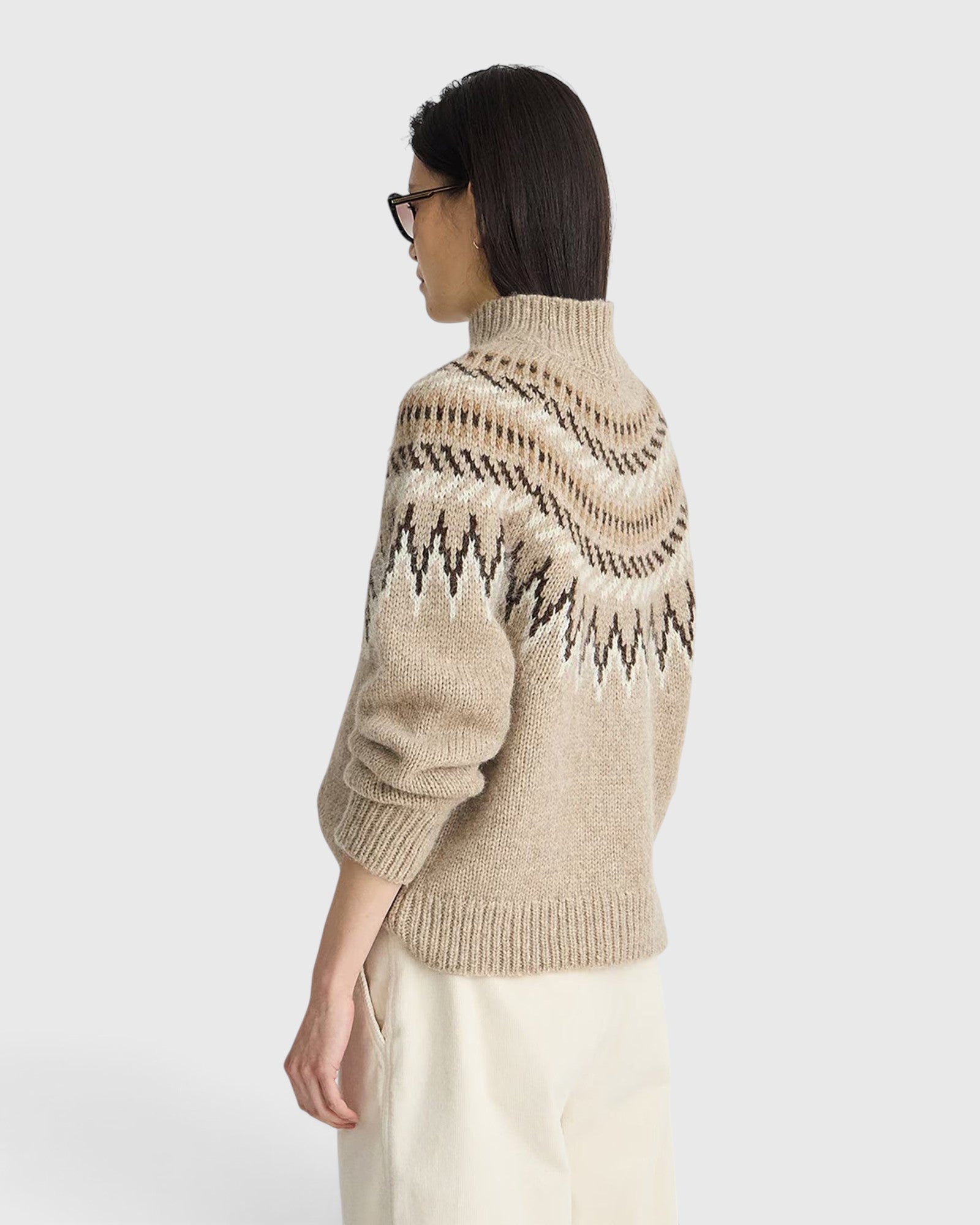 Model wearing a JONES + CO oatmeal mock neck sweater with a brown and cream fair isle knit pattern and ribbed trim.